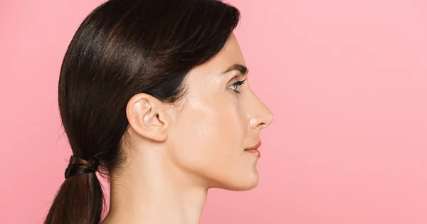Woman applying estrogen face cream.