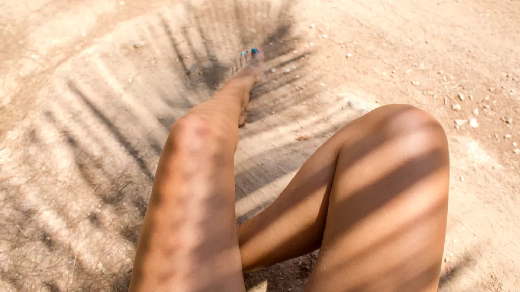 Woman sitting in the shade of a palm tree