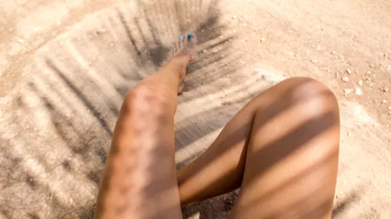 Woman sitting in the shade of a palm tree