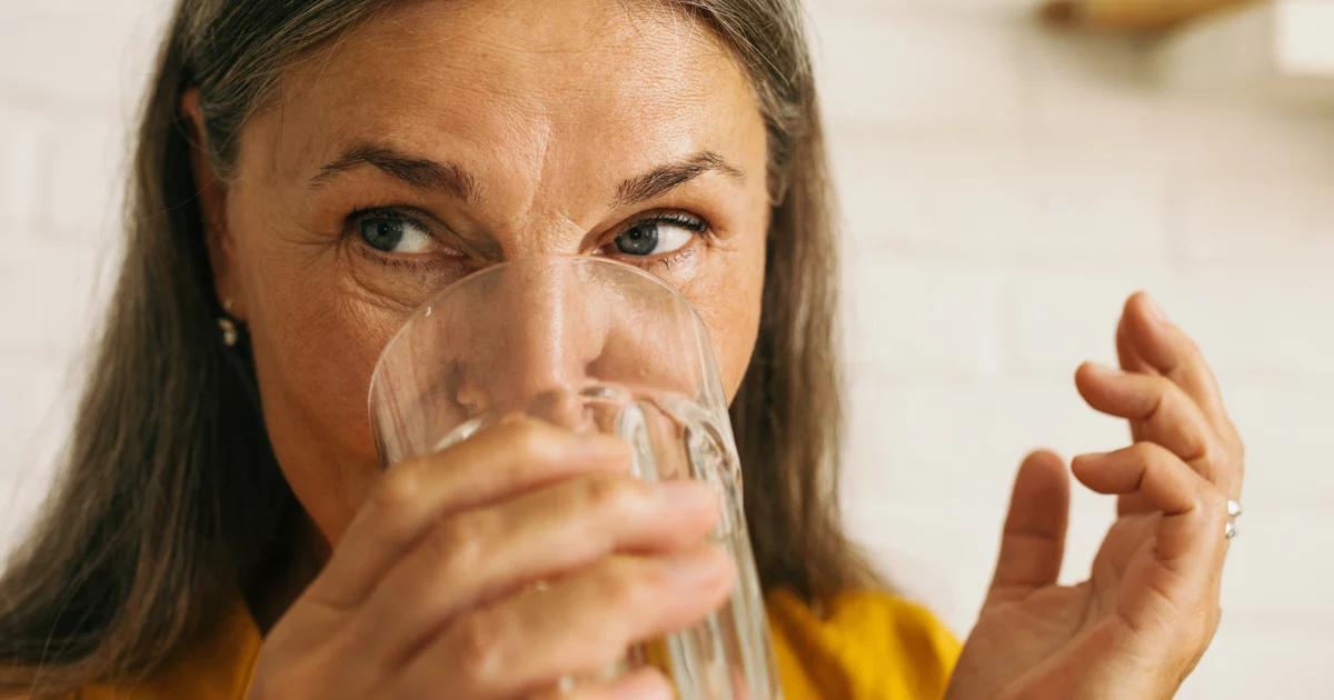 Woman taking an oral estrogen pill.
