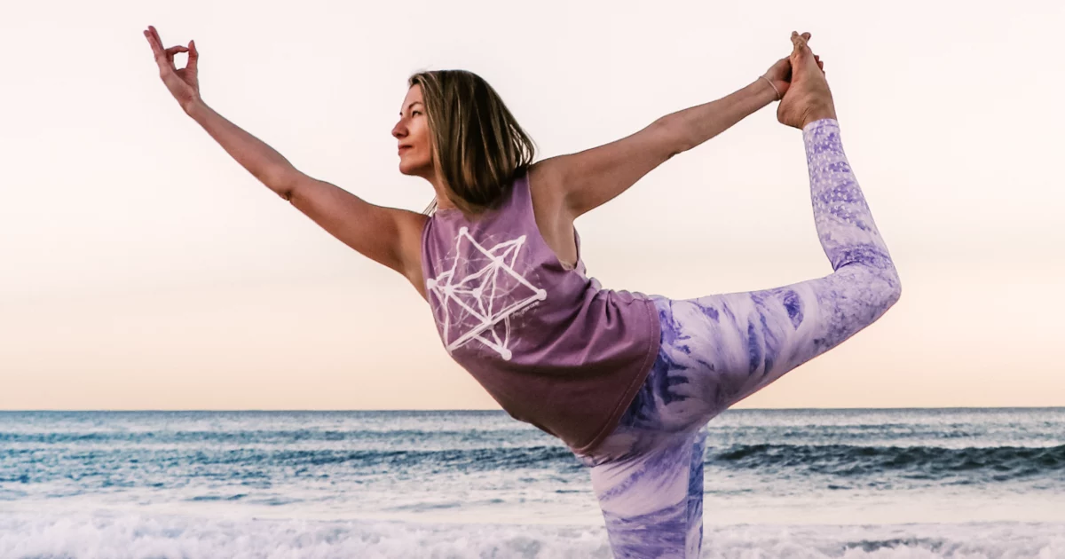 Woman doing yoga on beach.